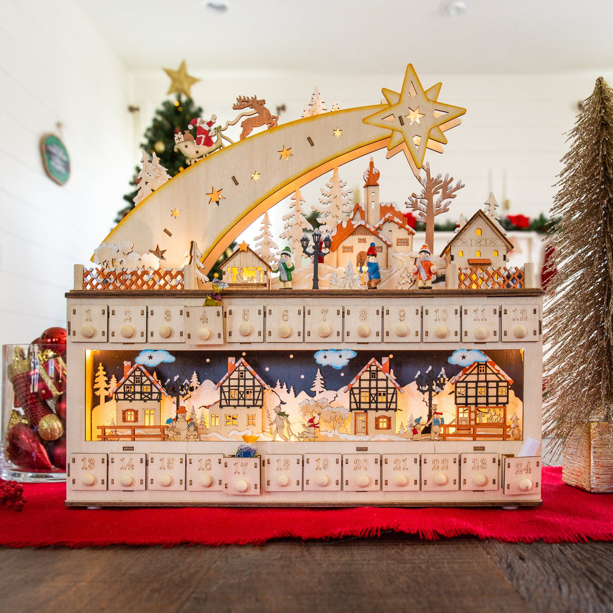 Wooden shooting star Christmas advent calendar with warm LED light hanging on a festive wall display