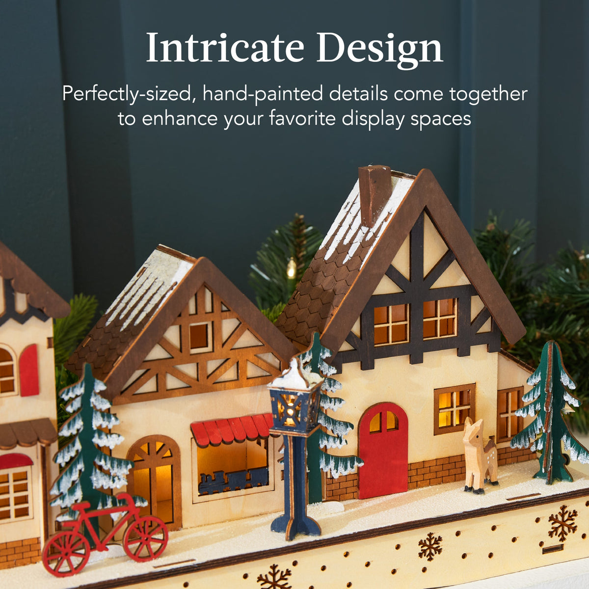 Pre-lit wooden Christmas village with warm LED lights arranged as festive mantel decor