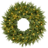 Pre-lit cedar cypress Christmas wreath glowing with twinkling LED lights on front door