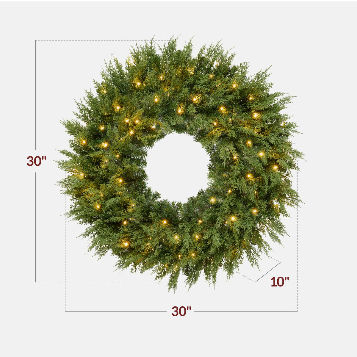 Pre-lit cedar cypress Christmas wreath glowing with twinkling LED lights on front door
