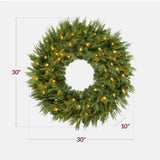 Pre-lit cedar cypress Christmas wreath glowing with twinkling LED lights on front door