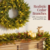 Pre-lit cedar cypress Christmas wreath glowing with twinkling LED lights on front door