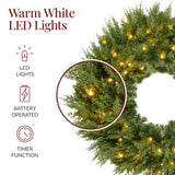 Pre-lit cedar cypress Christmas wreath glowing with twinkling LED lights on front door