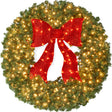 Pre-lit artificial fir Christmas wreath with decorative bow and glowing LED lights on display