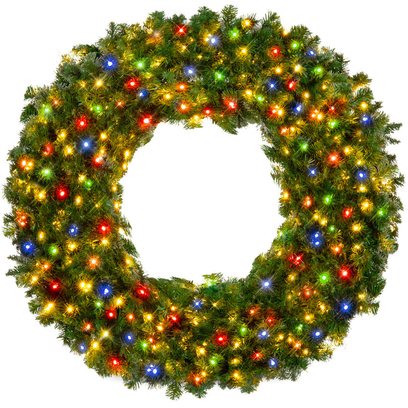 Pre-lit artificial fir Christmas wreath glowing with multicolor LED lights on a wooden door
