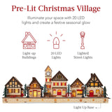 Pre-lit wooden Christmas village with warm LED lights arranged as festive mantel decor
